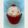 Πορσελάνινο διακοσμητικό σε σχήμα cup cake με λευκό γλάσο και χρωματιστή τρούφα. σε κόκκινη βάση