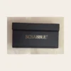 Επιτραπέζιο παιχνίδι Scrabble Travel Edition σε μαύρη κασετίνα με πτυσσόμενο ταμπλό και πλαστικά πλακίδια